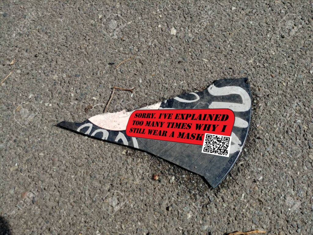 A shard of a broken record on the floor, has a sticker on it that reads: Sorry. I've explained too many times why i still wear a mask. And a QR-Code, leads to the Open Letter to our Comrades, linked bellow in the text