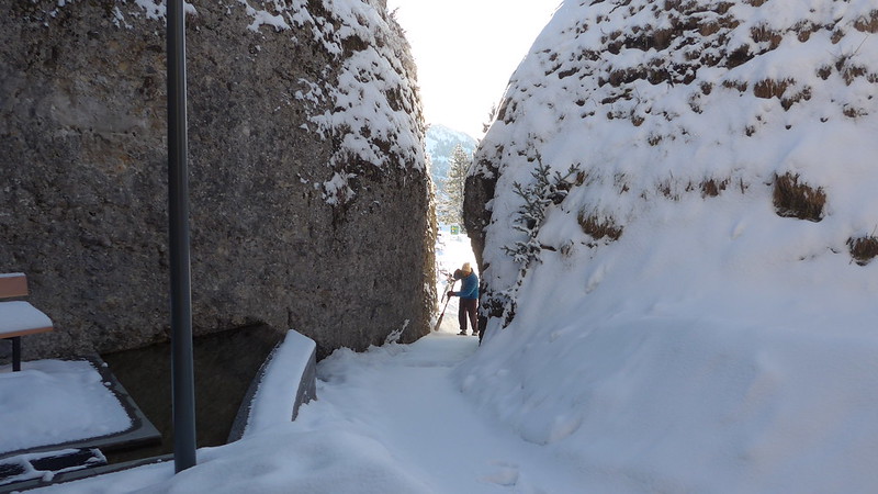 I guy seems stuck between two rocks as he clears the snow