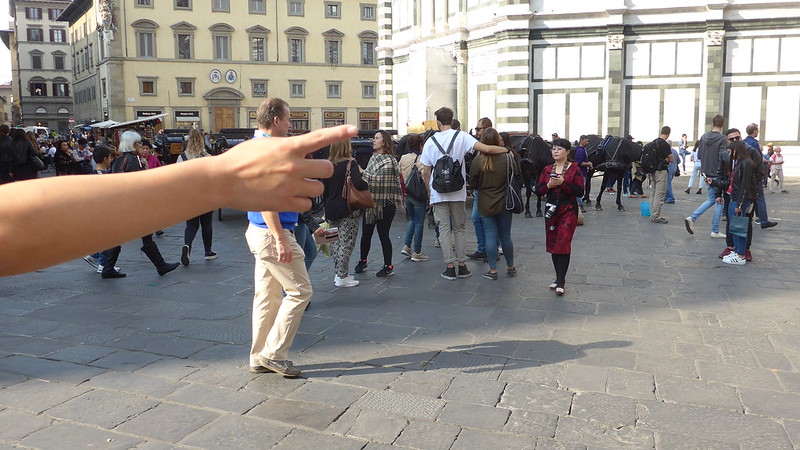 A crowd of tourists in Florence, but a hand point to the right